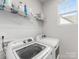 Efficient laundry room featuring a washer, dryer, and shelving for storage at 933 E 36Th St, Charlotte, NC 28205