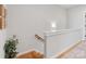 Upstairs landing featuring hardwood stairs, a modern railing, and a decorative plant at 933 E 36Th St, Charlotte, NC 28205