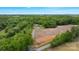 Aerial view of a property with trees, bare land, buildings, a road, and a car and truck parked nearby at 10016 Morgan Mill Rd, Monroe, NC 28110