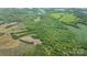 Aerial view of a property with farmland and densely wooded areas at 10016 Morgan Mill Rd, Monroe, NC 28110