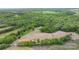Aerial view of a property with trees, bare land, buildings, a road, and a car parked nearby at 10016 Morgan Mill Rd, Monroe, NC 28110