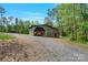 Rustic barn featuring weathered wood and a gravel driveway at 10016 Morgan Mill Rd, Monroe, NC 28110