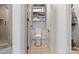 Bright bathroom featuring a toilet, storage shelving, and a tile surround shower at 10016 Morgan Mill Rd, Monroe, NC 28110