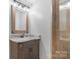 Bathroom vanity featuring bronze fixtures and a tile surround shower at 10016 Morgan Mill Rd, Monroe, NC 28110