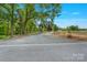 Gravel driveway leading to a property surrounded by lush green trees, offering a secluded setting at 10016 Morgan Mill Rd, Monroe, NC 28110