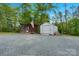 Two outbuildings with gravel driveway and exterior featuring weathered wood and white metal at 10016 Morgan Mill Rd, Monroe, NC 28110
