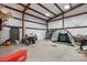 Spacious metal building featuring a garage area with an ATV, golf netting, and overhead lighting at 10016 Morgan Mill Rd, Monroe, NC 28110