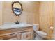 Nicely appointed powder room featuring a wood vanity with a quartz countertop and wood paneling at 10016 Morgan Mill Rd, Monroe, NC 28110