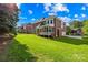 Expansive backyard featuring lush green lawn, mature trees, and a screened in porch at 10024 Hazelview Dr, Charlotte, NC 28277