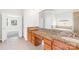 Ensuite bathroom showcasing double sinks with a granite countertop and a view into the carpeted bedroom at 10024 Hazelview Dr, Charlotte, NC 28277