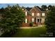 Charming brick home featuring arched windows, dark shutters, and a covered porch entry at 10024 Hazelview Dr, Charlotte, NC 28277