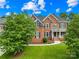 Beautiful two-story brick home with well-manicured lawn and mature trees at 10024 Hazelview Dr, Charlotte, NC 28277
