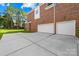 Exterior view of a brick home showcasing a two-car garage and backyard at 10024 Hazelview Dr, Charlotte, NC 28277