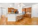 Beautiful kitchen with granite countertops, rich wood cabinetry, stainless appliances and breakfast bar with seating at 10024 Hazelview Dr, Charlotte, NC 28277