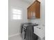 Functional laundry room with a modern washer and dryer, utility sink, and storage cabinet at 10024 Hazelview Dr, Charlotte, NC 28277