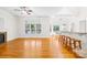 Open-concept living space with hardwood floors, ceiling fan, fireplace, bar top and generous natural light at 10024 Hazelview Dr, Charlotte, NC 28277