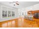 Spacious living room featuring hardwood floors, large windows, and an open floor plan adjacent to the kitchen area at 10024 Hazelview Dr, Charlotte, NC 28277