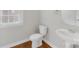 Cozy powder room with pedestal sink, toilet, and window at 10024 Hazelview Dr, Charlotte, NC 28277