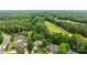 A stunning aerial view of the neighborhood with its mature trees and lush greenery, with golf course in the distance at 10317 Clubhouse View Ln, Mint Hill, NC 28227