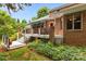 Outdoor living space with a multi-level deck, lush landscaping, and charming brick exterior at 10317 Clubhouse View Ln, Mint Hill, NC 28227