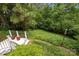 A view of the serene backyard from the deck, surrounded by lush greenery and mature trees at 10317 Clubhouse View Ln, Mint Hill, NC 28227