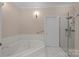 Bathroom featuring a jacuzzi tub, glass shower, and tiled floors at 10317 Clubhouse View Ln, Mint Hill, NC 28227