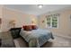 Comfortable bedroom featuring blue patterned bedding, soft lighting, and a bright window view at 10317 Clubhouse View Ln, Mint Hill, NC 28227