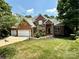 Beautiful brick home featuring a three-car garage and a meticulously manicured lawn and landscaping at 10317 Clubhouse View Ln, Mint Hill, NC 28227