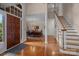Elegant foyer with gleaming hardwood floors, staircase, chandelier, and view of the dining room at 10317 Clubhouse View Ln, Mint Hill, NC 28227