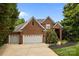 Charming brick home featuring a well-manicured lawn, mature trees, and a three car attached garage at 10317 Clubhouse View Ln, Mint Hill, NC 28227