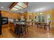 A kitchen with an island, wooden cabinets, and an adjacent dining area with large windows at 10317 Clubhouse View Ln, Mint Hill, NC 28227