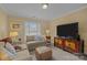 Cozy living room showcasing a window with blinds and a large TV on a decorative console at 10317 Clubhouse View Ln, Mint Hill, NC 28227
