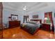 A beautiful main bedroom is illuminated by natural light, complemented by a tray ceiling, hardwood floors, and tasteful decor at 10317 Clubhouse View Ln, Mint Hill, NC 28227