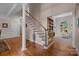 Elegant staircase with wood floors and view into the formal living room at 10317 Clubhouse View Ln, Mint Hill, NC 28227