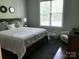 Bright bedroom featuring a comfortable bed, a large window, and simple stylish décor at 104 Bunker Way # 1001, Mooresville, NC 28117