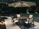 Outdoor patio area with a fire pit table, four chairs, and patio umbrella with string lights at 104 Bunker Way # 1001, Mooresville, NC 28117