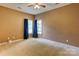This is a bedroom with beige carpet, tan walls, a ceiling fan, and a window with curtains at 10927 Chrudan Dr, Charlotte, NC 28262