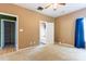 This is a carpeted bedroom with tan walls and a ceiling fan. There is a bathroom and closet nearby at 10927 Chrudan Dr, Charlotte, NC 28262