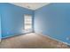 This is a carpeted bedroom with blue walls and a window with blinds at 10927 Chrudan Dr, Charlotte, NC 28262