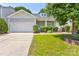 Well-maintained single-story house with attached garage, manicured lawn, and inviting front porch at 10927 Chrudan Dr, Charlotte, NC 28262