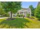 Charming single-story home with a manicured lawn, mature tree, and inviting front porch at 10927 Chrudan Dr, Charlotte, NC 28262