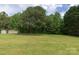 Large grassy backyard with some mature trees and greenery and storage shed for extra storage at 1274 Carpenter Springs Dr, Dallas, NC 28034