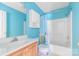 Bright bathroom with blue walls, vanity, shower with curtain, and ample storage at 1274 Carpenter Springs Dr, Dallas, NC 28034