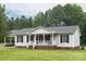 Charming single-story home with a inviting front porch and well-maintained lawn and mature landscaping at 1274 Carpenter Springs Dr, Dallas, NC 28034