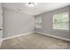 Bedroom with neutral paint, carpeted floor and two windows with outside view at 14034 Cedar Pond Cir, Huntersville, NC 28078