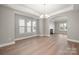 Bright living room with many windows, hardwood floors, and modern lighting fixture at 14034 Cedar Pond Cir, Huntersville, NC 28078