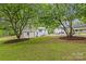 Backyard featuring a white brick house, wooden pergola, detached garage, and mulched landscaping at 1814 Brookdale Ave, Charlotte, NC 28210