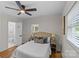 A comfortable bedroom with a ceiling fan, neutral decor, and a window with blinds for natural light at 1814 Brookdale Ave, Charlotte, NC 28210