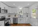 Updated kitchen with stainless appliances, white cabinets, and hardwood floors at 1814 Brookdale Ave, Charlotte, NC 28210