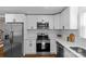 Bright kitchen features stainless appliances, white cabinets and countertops, and hardwood floors at 1814 Brookdale Ave, Charlotte, NC 28210